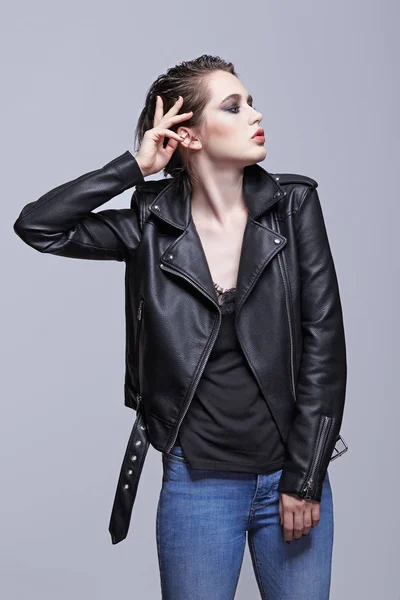 Portrait of female in black leather jacket. Woman with unusual beauty evening makeup. Girl with perfect skin and violet - black eye shadows make-up.