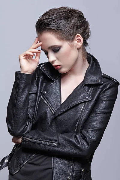 Portrait of female in black leather jacket. Woman with unusual beauty evening makeup. Girl with perfect skin and violet - black eye shadows make-up.