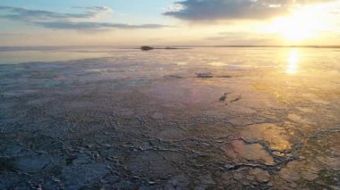 gün batımında sürüklenen buz ile donmuş göl görüntüleri