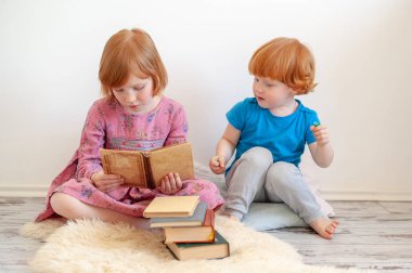 Büyük kız kardeşi kitap kardeşi için okur