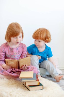 Büyük kız kardeşi kitap kardeşi için okur