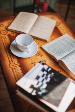 Kupası ve eski ahşap masa kitap