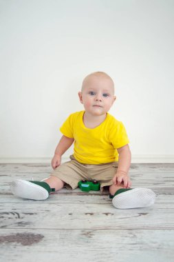 Parlak sarı tişört bir oyuncak araba ile erkek bebek