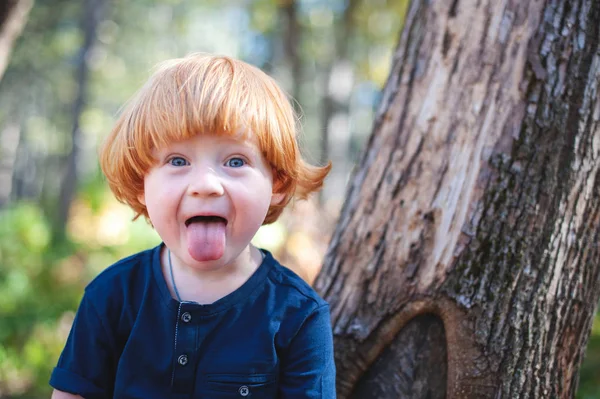 Rothaariger Junge Mit Langen Haaren Und Heraushängender Zunge — Stockfoto