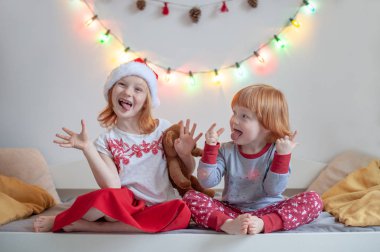 Bir Noel ortamda bir yatakta kardeş otur