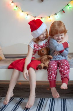 Bir Noel ortamda bir yatakta kardeş otur