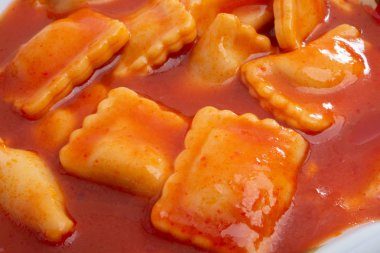 beyaz bir arka plan üzerinde domates soslu ravioli