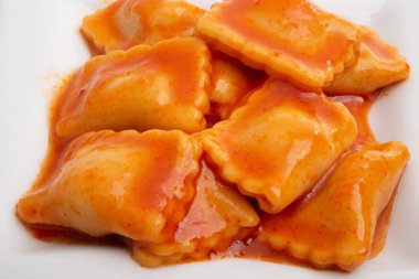 beyaz bir arka plan üzerinde domates soslu ravioli