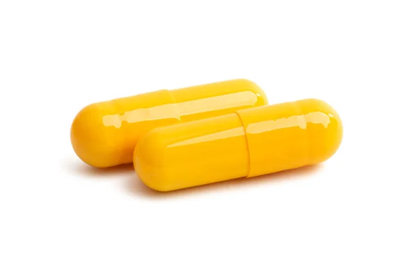 Изолированные желтые капсулы — стоковое фото
