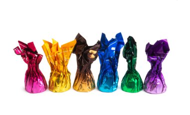 Beyaz arka planda izole edilmiş renkli ambalajlı çikolata şekerleri.