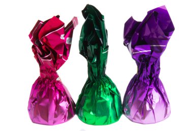 Beyaz arka planda izole edilmiş renkli ambalajlı çikolata şekerleri.