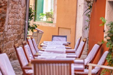 Hırvatistan 'ın dar Avrupa sokaklarında kafe masaları