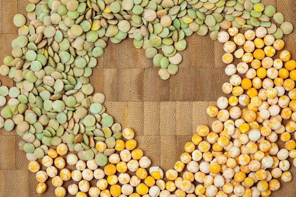 peas and lentils scattered on a textured cork surface
