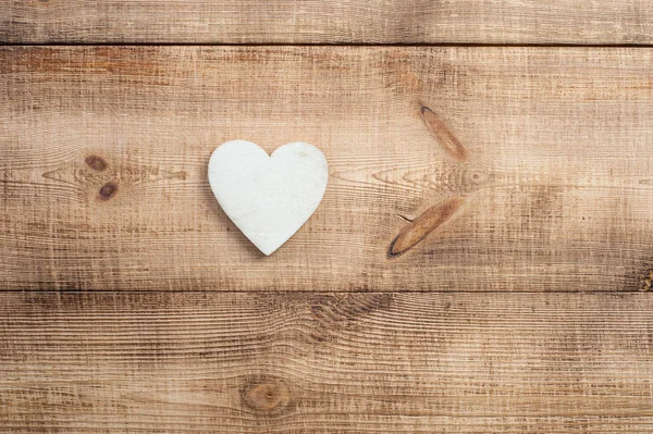 Houten hart mooi geplaatst op een vintage houten achtergrond. — Stockfoto