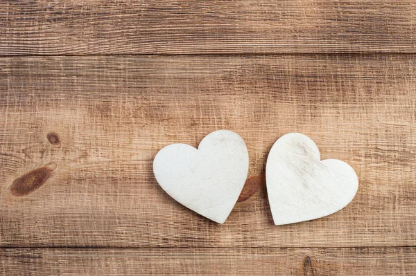 Due cuore di legno su uno sfondo di legno vintage . — Foto Stock