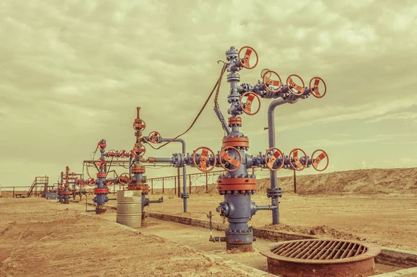 Pozos con armadura de válvula en un campo petrolífero . — Foto de Stock