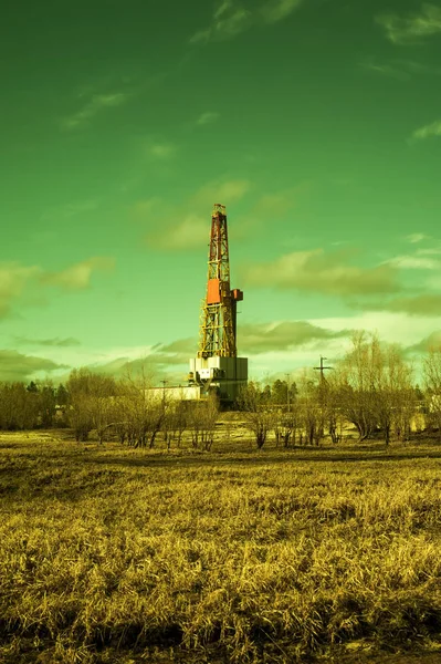 Paisaje con una plataforma de perforación en un campo de petróleo. Día soleado, principios de primavera. Paisaje industrial. Rusia, Siberia Occidental . — Foto de Stock