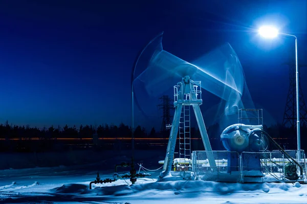 Working oil pump at night time. Oilfield during winter. Oil and gas concept. Motion blur. — Stock Photo, Image