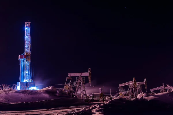 Impianto di perforazione di petrolio e gas di notte. Impianto di perforazione e funzionamento jack pompa sulla piattaforma petrolifera . — Foto Stock