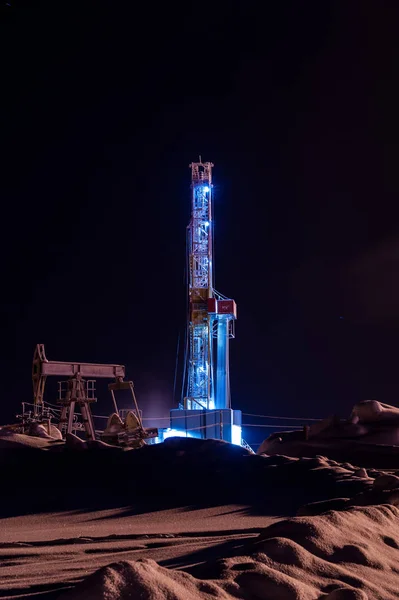 石油・ ガス掘削装置の夜。掘削装置とポンプ ジャック石油プラットフォームで操作. — ストック写真