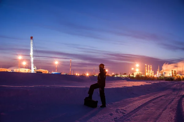 Olja då arbetstagaren i oljefält. Pumpa jack och ingenjör på en vinter sunset himmel bakgrund. Västra Sibirien. — Stockfoto