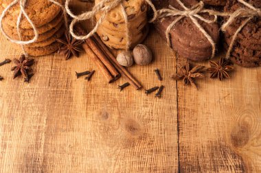 Çeşitli kurabiye, yulaf kurabiye, Çikolatalı Bisküvi ve baharat karanlık rustik ahşap tablo.