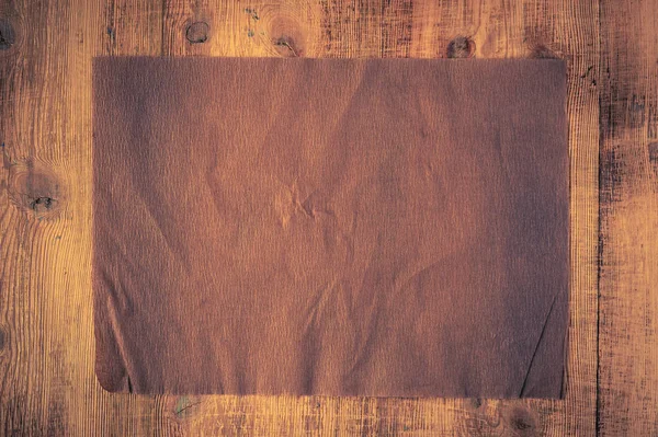 Grunge crumpled brown beige paper texture on wood background. Distressed and industrial background. — Stock Photo, Image