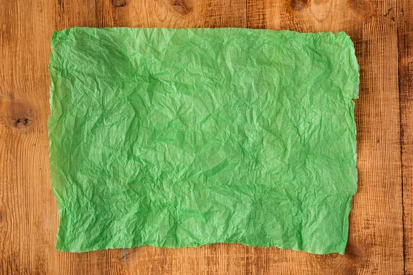 Grunge accartocciato carta verde ciano texture su sfondo di legno. Contesto angosciato e industriale . — Foto Stock