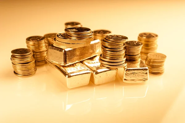 Lingotes de oro y pila de monedas. Antecedentes del concepto financiero bancario. Comercio de metales preciosos . — Foto de Stock