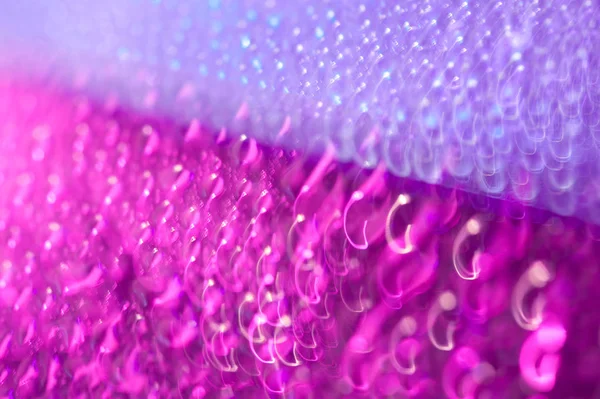 Drops on a shiny surface with a motion blur effect. Violet tonality in the style of the 80-90s. — Stock Photo, Image