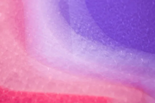 Gotas em uma superfície brilhante com um efeito de borrão de movimento. Tonalidade violeta no estilo dos anos 80-90 . — Fotografia de Stock