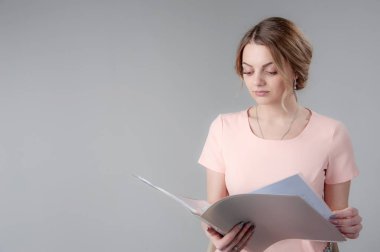 Nötr gri arka planda sarı saçlı genç çekici bir kadının portresi.