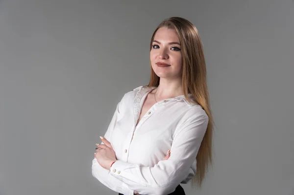 Retrato de uma jovem mulher atraente com cabelo loiro em um fundo cinza neutro . — Fotografia de Stock