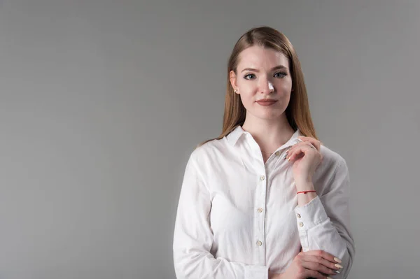 Porträt einer jungen attraktiven Frau mit blonden Haaren auf neutralem grauen Hintergrund. — Stockfoto