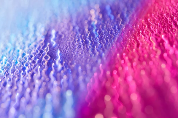 Gotas em uma superfície brilhante com um efeito de borrão de movimento. Tonalidade violeta no estilo dos anos 80-90 . — Fotografia de Stock