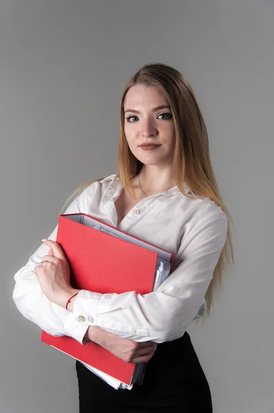 Portret van een jonge aantrekkelijke vrouw met blond haar op een neutrale grijze achtergrond. — Stockfoto