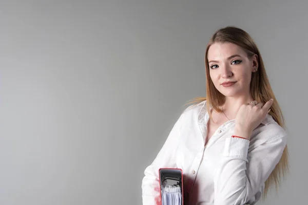 Retrato de uma jovem mulher atraente com cabelo loiro em um fundo cinza neutro . — Fotografia de Stock