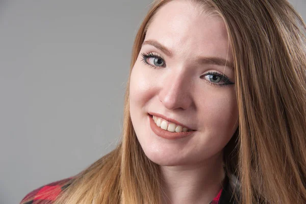 Portrait d'une jeune femme séduisante aux cheveux blonds sur fond gris neutre . — Photo