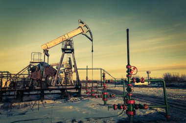 Yağ pompası jakı ve bir petrol sahasında wellhead. Madencilik ve petrol endüstrisi. Güç üretimi konsepti.