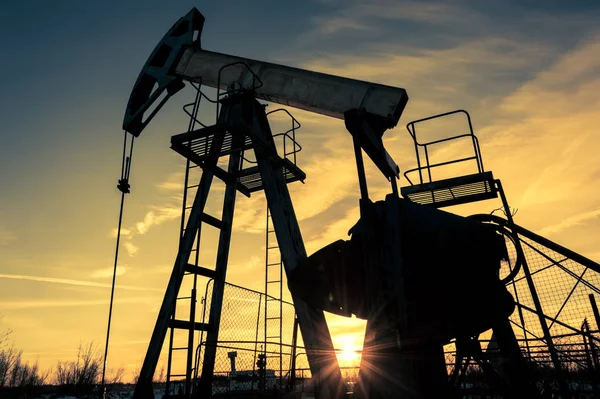 Wagenheber und Bohrkopf einer Ölpumpe auf einem Ölfeld. Bergbau und Ölindustrie. Stromerzeugungskonzept. — Stockfoto