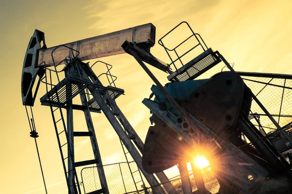 Yağ pompası jakı ve bir petrol sahasında wellhead. Madencilik ve petrol endüstrisi. Güç üretimi konsepti. — Stok fotoğraf