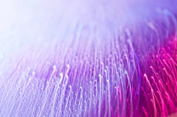 Gouttes sur une surface brillante avec un effet de flou de mouvement. Tonalité violette dans le style des années 80-90 . — Photo