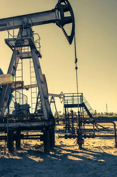 Oil Pumpjack, industriell utrustning. Gungmaskiner för kraftproduktion. Utvinning av olja. — Stockfoto