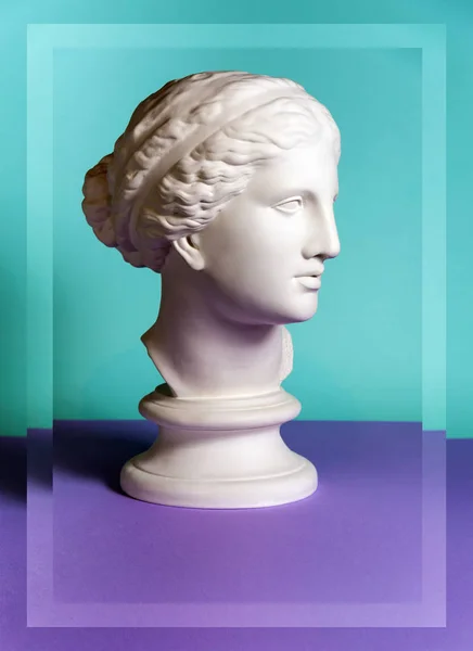 White gypsum copy of ancient statue Venus head on a green purple background. Plaster sculpture woman face. — Stockfoto