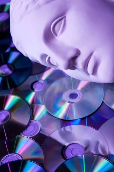 Estatua antigua de la cabeza de Venus de cerca sobre un fondo de CD de purpurina. Concepto de música, estilo, vintage . — Foto de Stock