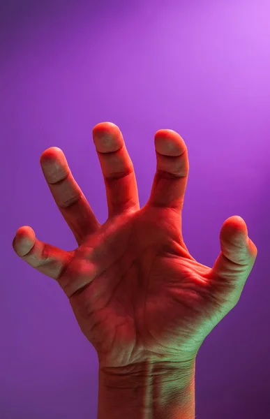 Mãos coloridas fluorescentes brilhantes isoladas em um fundo escuro. Close-up . — Fotografia de Stock