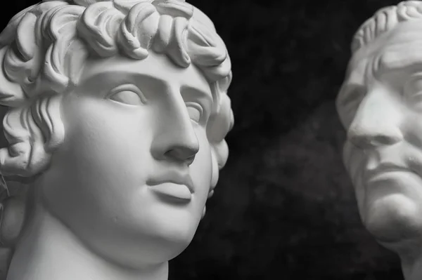 Copia de yeso de la antigua estatua de Augusto y Antinoo cabeza sobre fondo de textura oscura. Escultura de yeso cara de hombre . — Foto de Stock