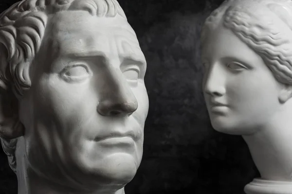 Gypsum copy of ancient statue Augustus and Venus head on dark textured background. Plaster sculpture mans face. — Stock Photo, Image