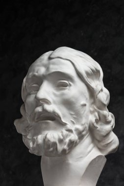 Koyu dokulu arka plan üzerinde antik heykeli John The Baptist baş Alçı kopya. Alçı heykel adam yüz.