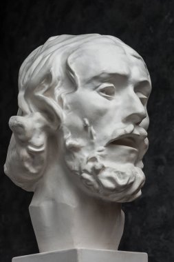 Koyu dokulu arka plan üzerinde antik heykeli John The Baptist baş Alçı kopya. Alçı heykel adam yüz.